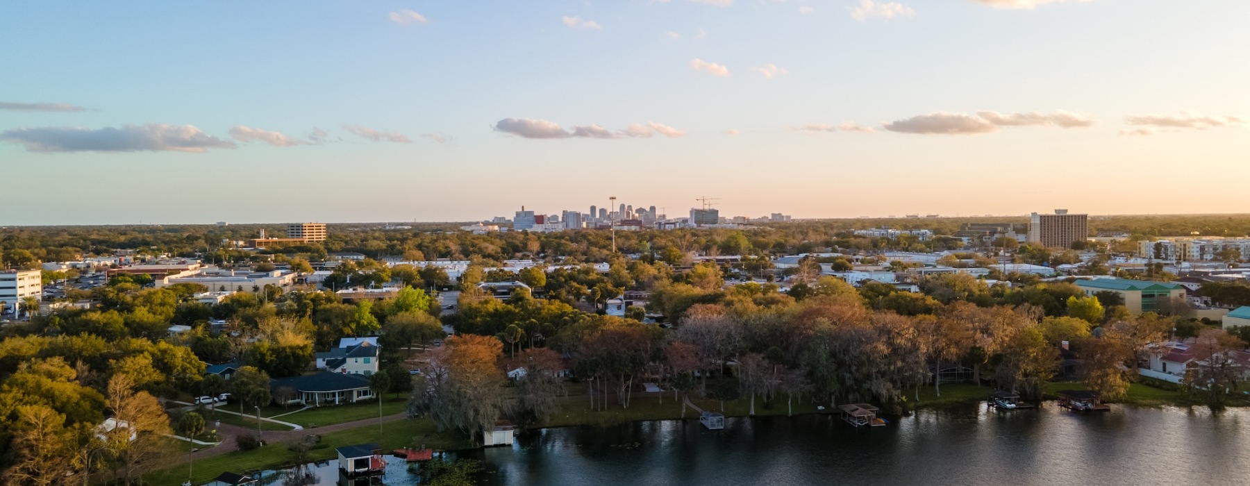 a body of water with trees and buildings around it
